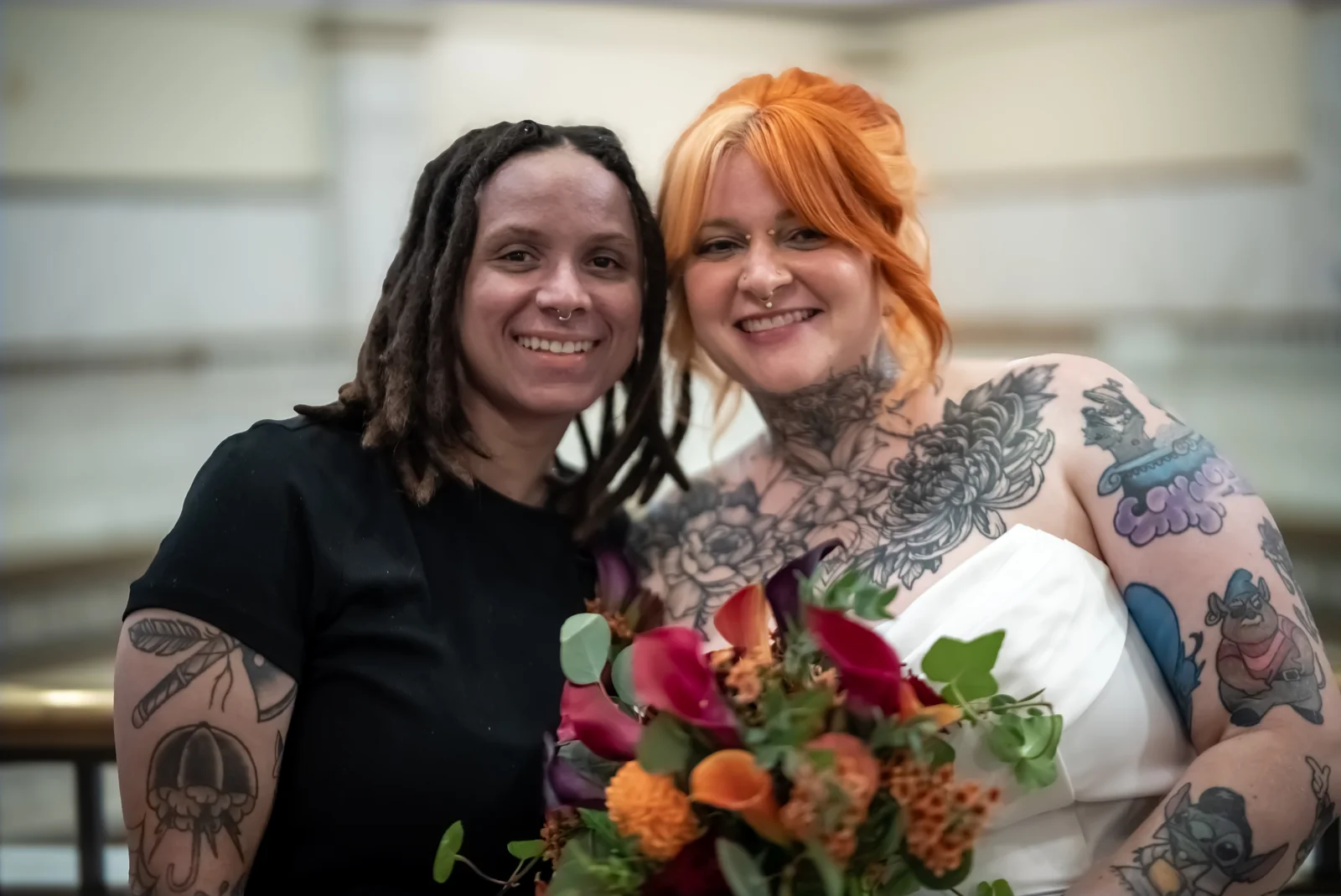 The couple smiling together with their wedding bouquet