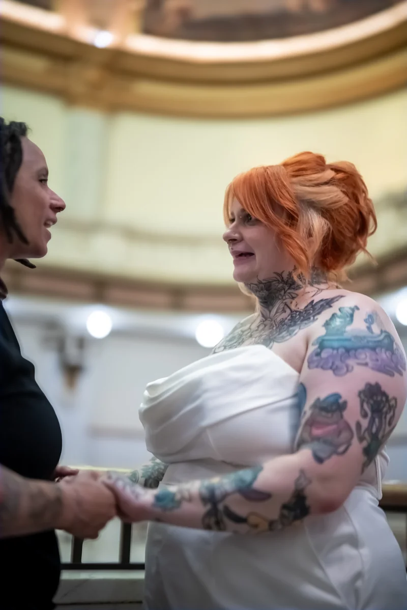 The couple holding hands during their ceremony