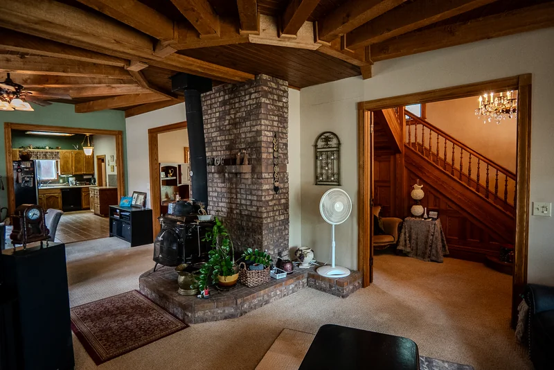 Timber beams, a brick stove, and a view into the adjoining rooms